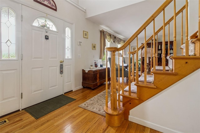entryway featuring light wood-type flooring, stairway, and baseboards