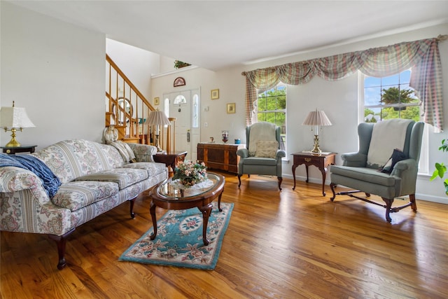 living room with stairs and wood finished floors