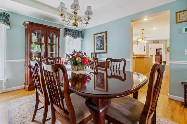 dining area featuring a chandelier, light wood-type flooring, baseboards, and recessed lighting