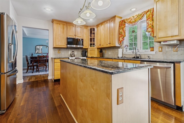 kitchen featuring appliances with stainless steel finishes, dark wood-type flooring, a center island, a sink, and glass insert cabinets