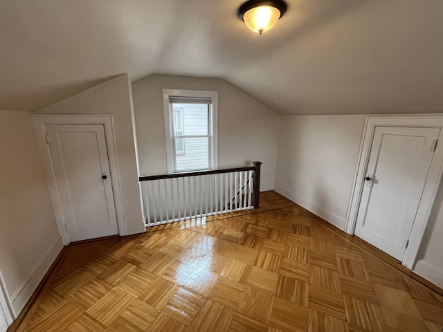 additional living space featuring baseboards and lofted ceiling