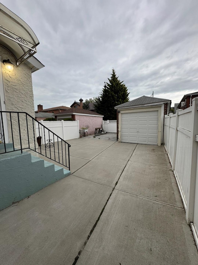 19-11 147th St, Flushing, NY 11357 - view of patio / terrace with an outdoor structure, fence, a garage, and concrete driveway