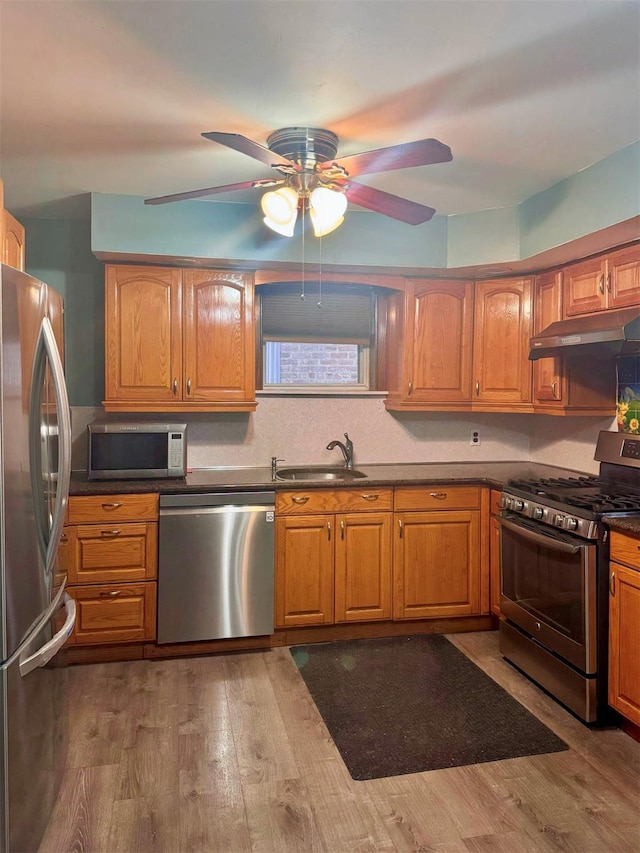 19-11 147th St, Flushing, NY 11357 - kitchen with appliances with stainless steel finishes, a sink, under cabinet range hood, a ceiling fan, and dark countertops