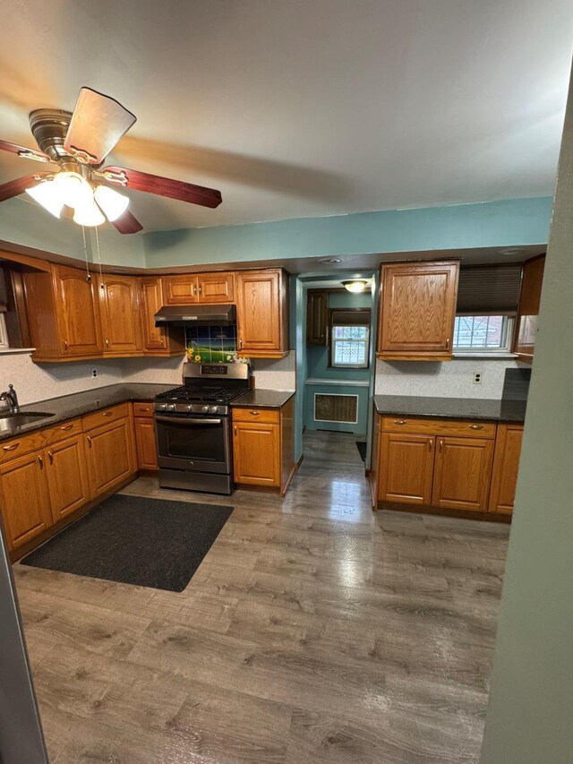 19-11 147th St, Flushing, NY 11357 - kitchen with stainless steel gas range, tasteful backsplash, dark countertops, and brown cabinets