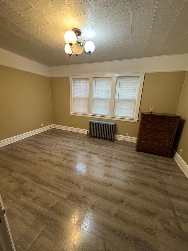 19-11 147th St, Flushing, NY 11357 - empty room with radiator, wood finished floors, and baseboards