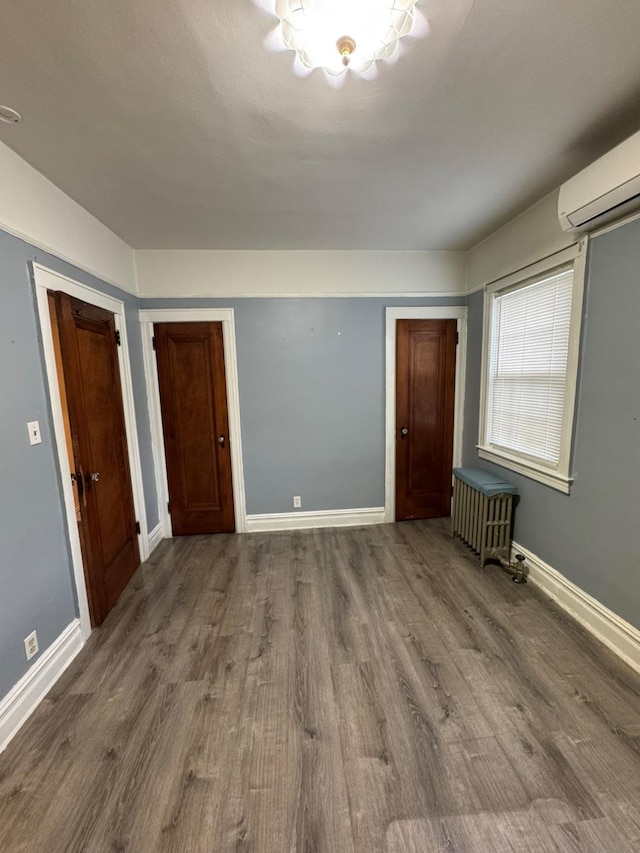 19-11 147th St, Flushing, NY 11357 - unfurnished room featuring a wall mounted air conditioner, radiator, and wood finished floors