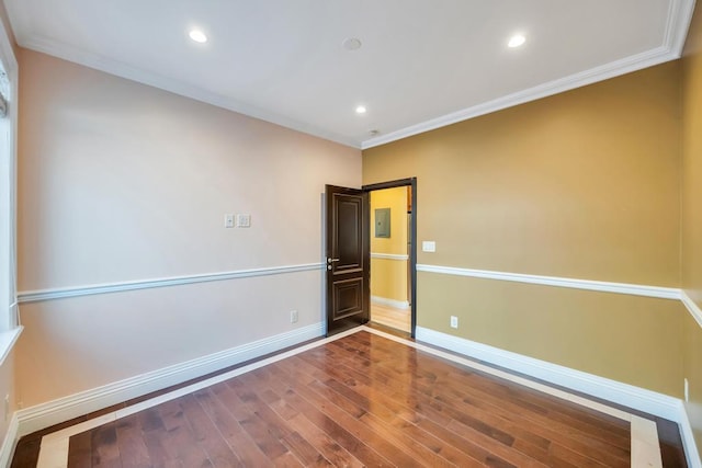 empty room with ornamental molding, wood finished floors, baseboards, and recessed lighting