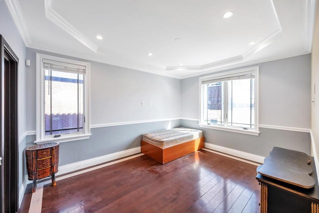 unfurnished bedroom featuring a tray ceiling, crown molding, wood finished floors, baseboards, and recessed lighting