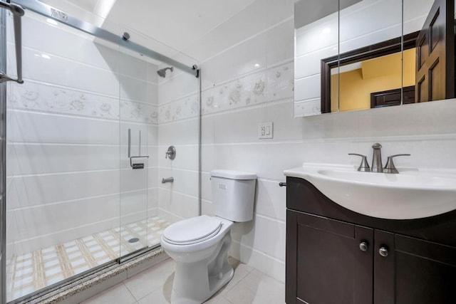 bathroom with a stall shower, toilet, vanity, and tile patterned floors