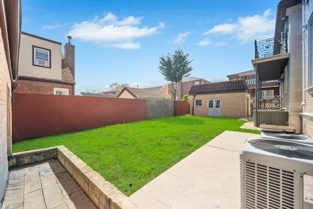 view of yard featuring an outdoor structure, central AC, and a patio