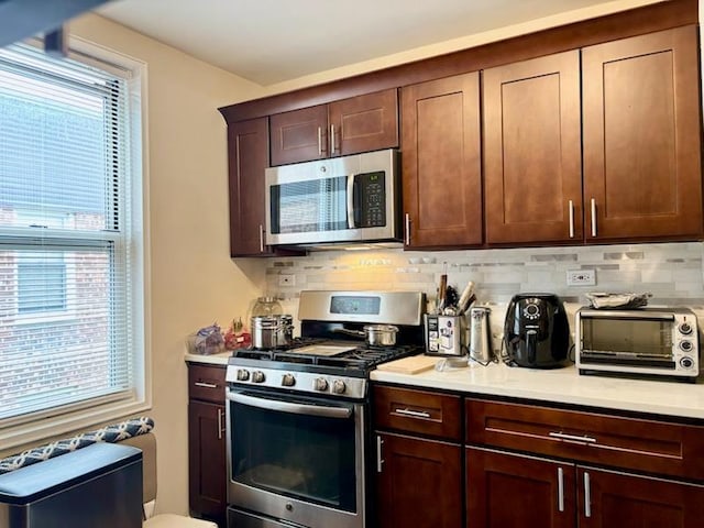 kitchen with stainless steel appliances, plenty of natural light, light countertops, and tasteful backsplash