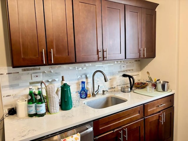 bar with a sink, tasteful backsplash, and stainless steel dishwasher