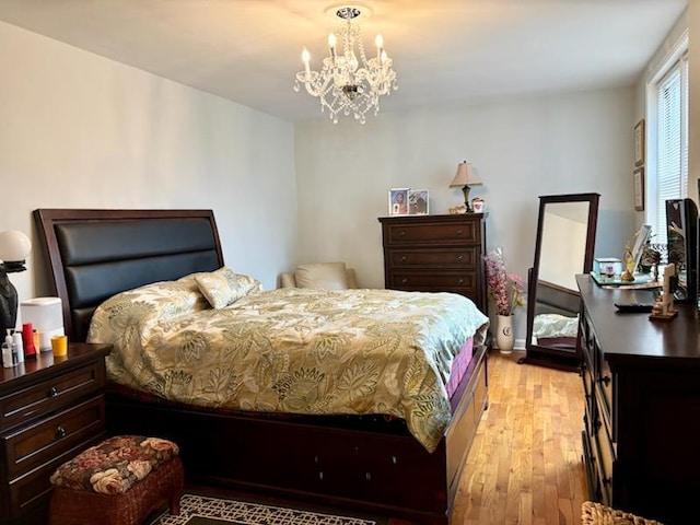 bedroom with light wood-style flooring and a chandelier