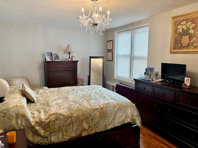 bedroom with a chandelier and wood finished floors