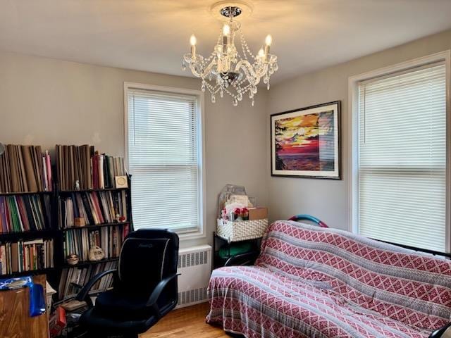 bedroom featuring radiator, wood finished floors, and a chandelier