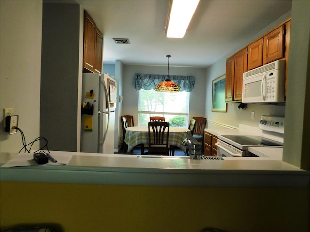 42 Touchstone Way, Millwood, NY 10546 - kitchen with white appliances, brown cabinetry, decorative light fixtures, and a peninsula