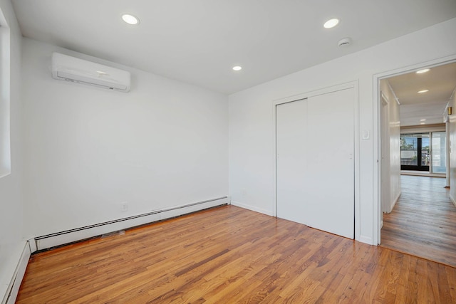 15940 95th St, Howard Beach, NY 11414 - unfurnished bedroom featuring a wall mounted air conditioner, a baseboard heating unit, wood finished floors, recessed lighting, and a closet