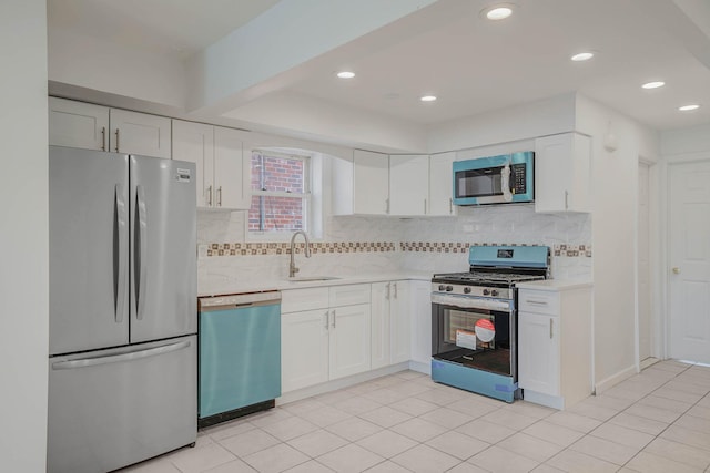 15940 95th St, Howard Beach, NY 11414 - kitchen with appliances with stainless steel finishes, a sink, light countertops, white cabinets, and backsplash