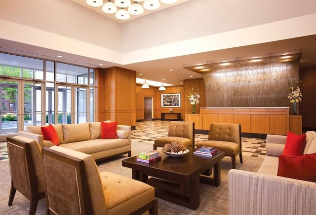 common area with a high ceiling, wooden walls, and recessed lighting