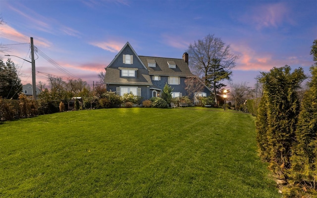 shingle-style home with a lawn and a chimney