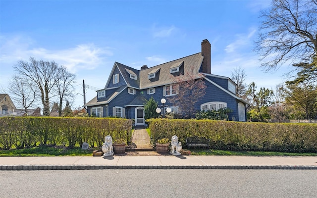 shingle-style home with fence and a chimney