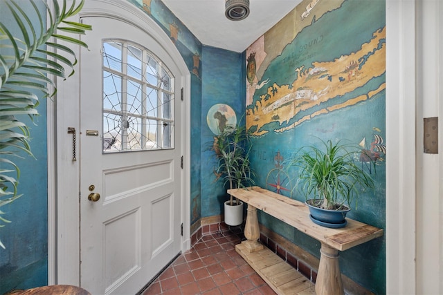 doorway to outside featuring dark tile patterned floors and baseboards