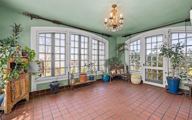 unfurnished sunroom with french doors and a chandelier