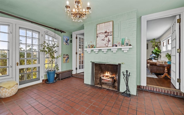 tiled living room with a fireplace and a chandelier