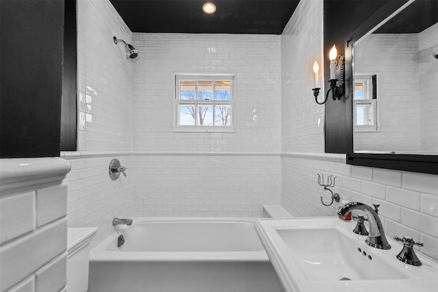 full bathroom with a sink, tile walls, and bathing tub / shower combination