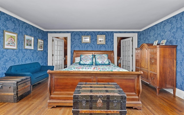 bedroom with wallpapered walls, wood finished floors, and ornamental molding