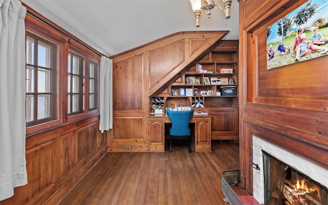 office space with wooden walls, dark wood-type flooring, a premium fireplace, and plenty of natural light
