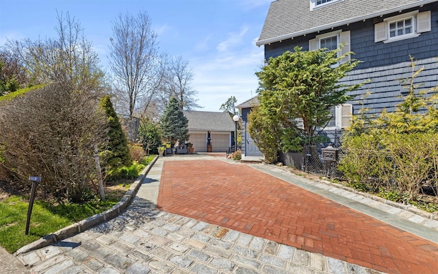 exterior space featuring roof with shingles and a garage