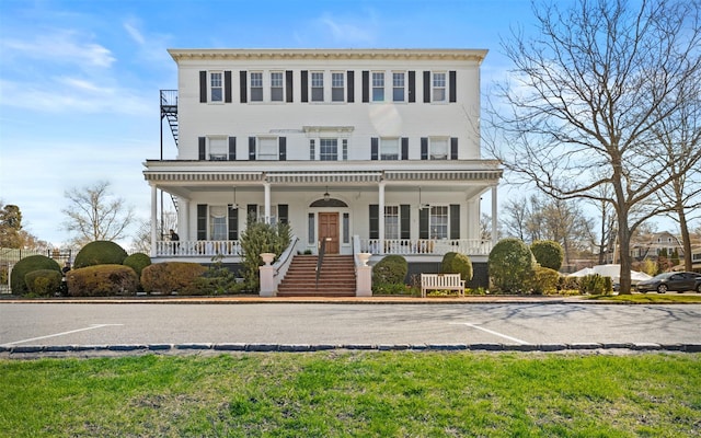 view of front facade with covered porch, uncovered parking, and stairs