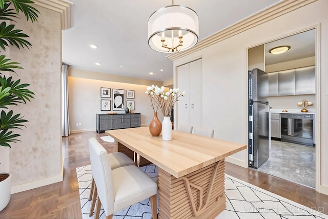 dining area with a chandelier, baseboards, wood finished floors, recessed lighting, and wine cooler