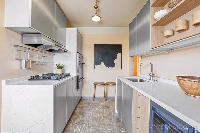 kitchen featuring open shelves, a sink, stainless steel gas cooktop, a warming drawer, and light countertops