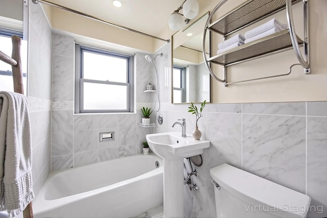 full bathroom with tile walls, toilet, and shower / tub combination
