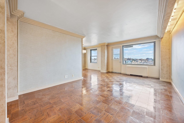 unfurnished room with radiator, baseboards, and crown molding