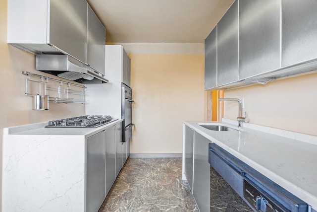 kitchen featuring a sink, stainless steel gas cooktop, dishwashing machine, a warming drawer, and dark marble finish floors