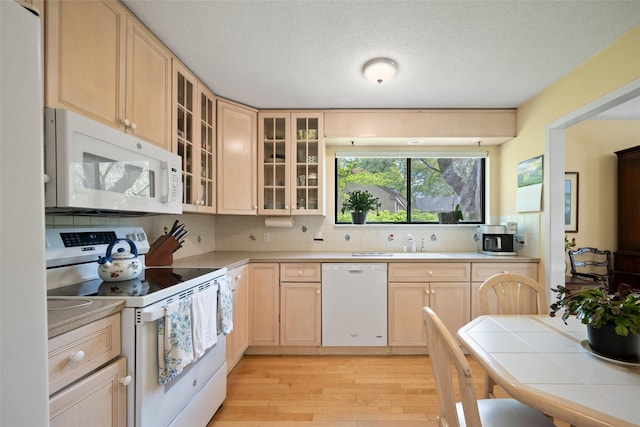 41 Heritage Hills Dr Unit A, Somers, NY 10589 - kitchen with white appliances, light brown cabinets, light wood finished floors, tasteful backsplash, and a textured ceiling