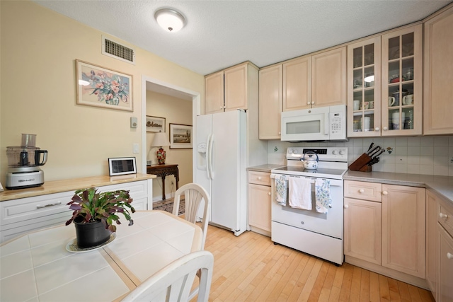 41 Heritage Hills Dr Unit A, Somers, NY 10589 - kitchen featuring white appliances, light wood-type flooring, glass insert cabinets, tasteful backsplash, and light brown cabinetry