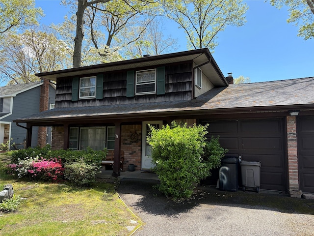 view of front facade with a garage, covered porch, and brick siding