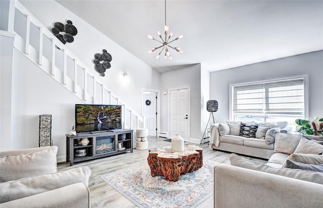 10 Butler Dr, Goshen, NY 10924 - living room featuring stairs, a chandelier, light wood-style flooring, and baseboard heating