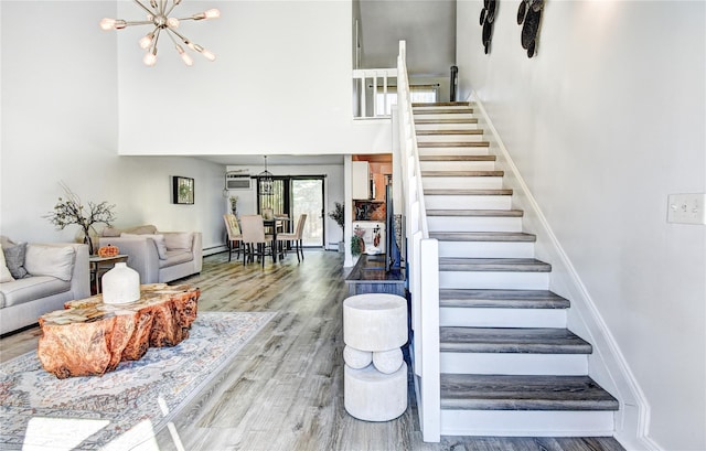 10 Butler Dr, Goshen, NY 10924 - staircase featuring a towering ceiling, a chandelier, wood finished floors, and baseboards