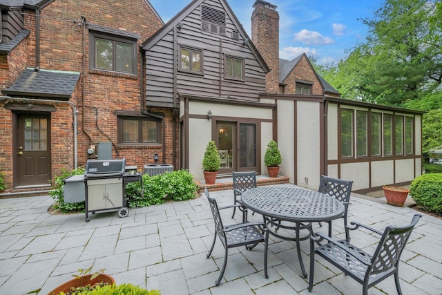 1 Wensley Dr, Great Neck, NY 11021 - rear view of property featuring a patio, a chimney, stucco siding, brick siding, and outdoor dining area