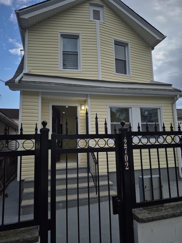 12702 97th Ave, Richmond Hill S, NY 11419 - view of front facade with a gate and a fenced front yard