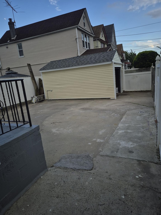 12702 97th Ave, Richmond Hill S, NY 11419 - view of side of property with fence, a chimney, and a shingled roof