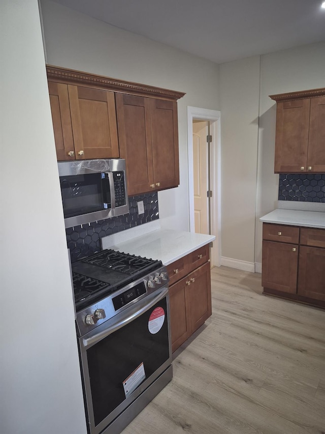 12702 97th Ave, Richmond Hill S, NY 11419 - kitchen with appliances with stainless steel finishes, light wood-style flooring, backsplash, and light countertops
