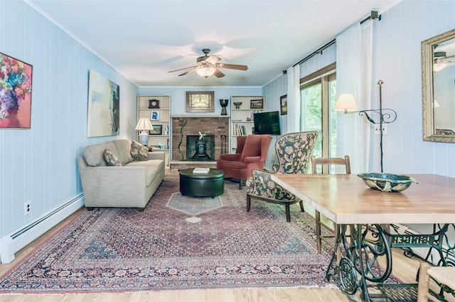 24 Overhill Ln, Warwick, NY 10990 - living room with a baseboard radiator, a ceiling fan, crown molding, wood finished floors, and a brick fireplace
