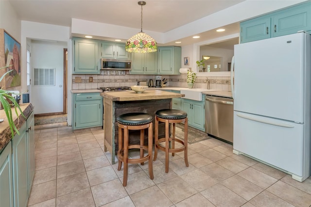 24 Overhill Ln, Warwick, NY 10990 - kitchen with stainless steel appliances, green cabinets, decorative backsplash, a center island, and a sink