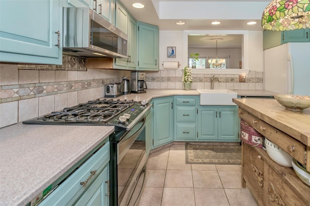 24 Overhill Ln, Warwick, NY 10990 - kitchen featuring stainless steel appliances, a sink, a chandelier, light countertops, and backsplash